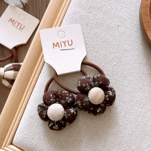 Chouchous à motif floral avec centre en peluche sur fond de bois texturé vintage