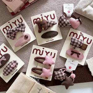 Flat lay of pink fabric hair clips and elastic ties with bear and star details