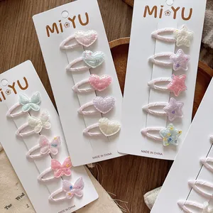 Détail de barrettes pailletées en forme de cœur et étoile pour filles aux tons pastel