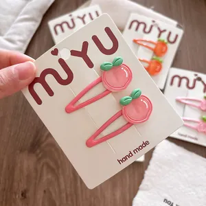 Paar schattige roze perzik haarclips voor meisjes op een houten achtergrond