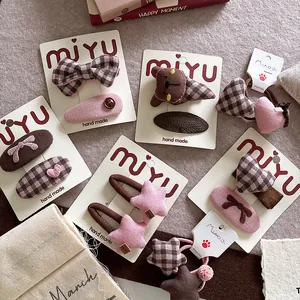 Detail of pink and brown fabric bow hair clips and elastic ties with handmade star patterns