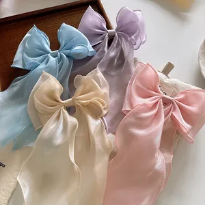 Detail of oversized organza bow hair clips in pastel pink, purple, blue and cream white