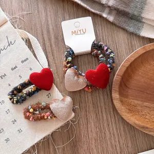 Dettaglio di accessori per capelli in maglia con clip BB e elastico con cuori