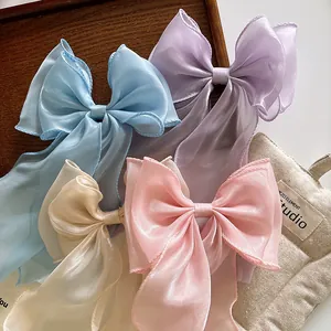 Detail of four pastel oversized organza bow hair clips with long streamers on a tray