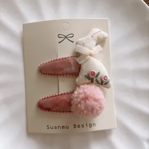 Detail of pink velvet clips featuring embroidered rabbit and faux fur pom pom