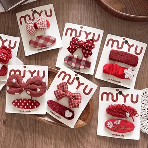 Detailed macro view of red fabric bow hair clips with lace and heart charms set