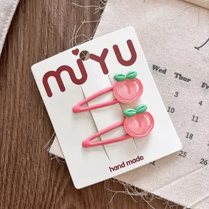 Detail van roze perzik haarclips voor meisjes op witte kaart op een rustieke houten tafel
