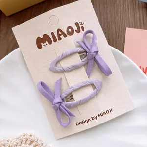 Détail de pinces à cheveux nuds en tissu lavande pour filles sur carte de présentation