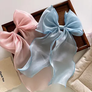 Macro detail of large organza ribbon bows in pink and light blue on a wooden tray