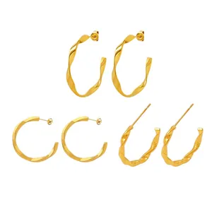 Three pairs of twisted gold hoop earrings with smooth and hammered metal textures