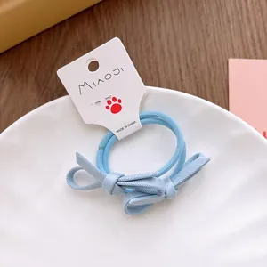 Détail d'un élastique à cheveux bleu clair avec nœud en tissu sur carte MIAOJI