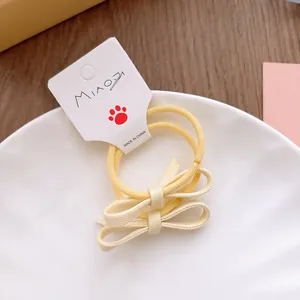 Détail de chouchous à nœuds aux couleurs acidulées présentés sur une assiette blanche