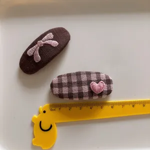Sweet fabric bow and heart pattern hair clips for children in brown and pink tones