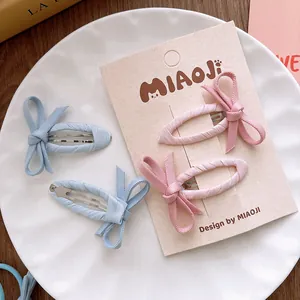 Détail de barrettes à cheveux avec nœuds en tissu rose et bleu pour petites filles
