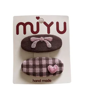 Two-piece fabric hair clips set with brown bow embroidery and pink checkered heart pattern