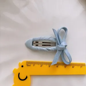 Pince à cheveux nœud bleu clair pour filles avec mesure de 5cm sur fond blanc épuré