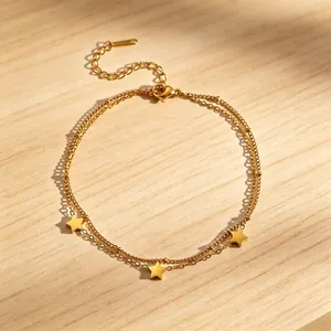 Elegant double-layered gold titanium steel anklet with star charms on a wooden surface