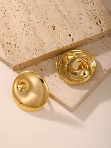 Detailed view of chunky gold dome earrings on elegant travertine stone display