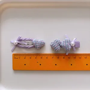 Set de barrettes violettes avec cœur pied-de-poule et nœud perlé sur plateau blanc