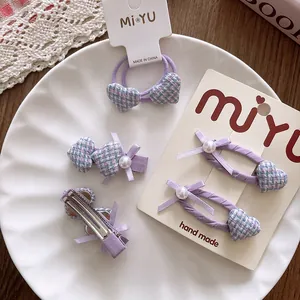 Vue détaillée d'un ensemble d'accessoires de cheveux violets avec nœuds et perles sur support