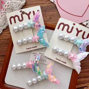Detailed view of sequined mermaid tail hair clips with pearls on a display card
