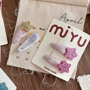 Detail of velvet BB clips featuring glittery star accents for kids hair styling