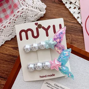 Detail of sequined mermaid tail hair clips with pearls and stars on a display card
