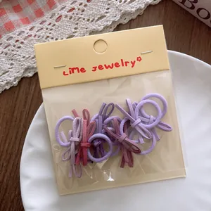 Detailed view of lavender bow hair ties in transparent packaging on a white plate