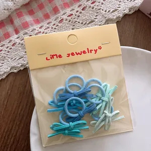 Detailed view of candy color bow hair ties in mini size for toddlers with retail packaging
