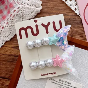 Macro shot of two handmade mermaid hair clips with pearls and sequins for young girls