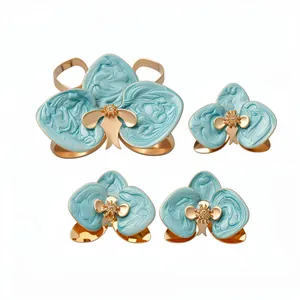 Elegante set di gioielli orchidea in smalto blu con bracciale rigido dorato e orecchini.