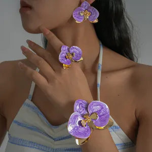Vista dettagliata di un set di gioielli floreali in smalto viola con bracciale, anello e orecchini
