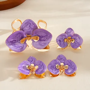 Vista ravvicinata del set di gioielli floreali in smalto viola con bracciale e orecchini.