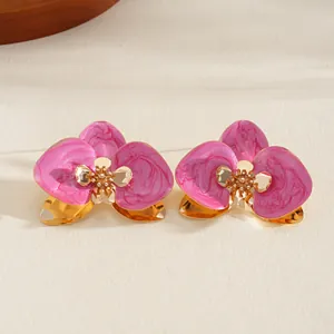 Dettaglio dei fiori in smalto rosa con accenti dorati su un braccialetto di metallo