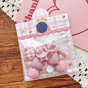 Détail d'élastiques à cheveux roses avec breloques cœur et étoile en paquet