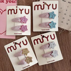 Detail showing velvet star hair clips set in pink, blue, gold and silver on packaging