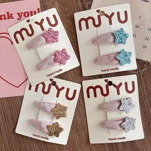 Detail of four pairs of velvet sequin star hair clips in pink, blue, gold and silver colors