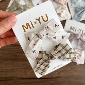 Set of two fabric bow hair clips with floral and plaid patterns for women