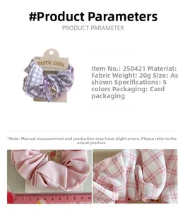 Detailed view of purple plaid and pink fabric scrunchies with white card packaging
