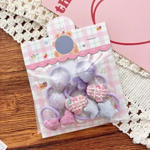 Détails d'élastiques à cheveux roses et violets avec cœurs en peluche et nœuds pour filles