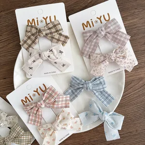 Floral and plaid fabric bow hair clips set in pastel colors on a display card