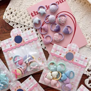 Vue à plat de mini élastiques colorés avec motifs cœur et nœud pour petites filles