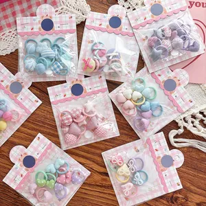 Détail d'élastiques à cheveux mignons avec motifs cœurs et nœuds en pack rose ours