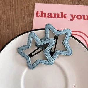 Détail de barrettes à cheveux en jean bleu clair en forme d'étoile dans un plat