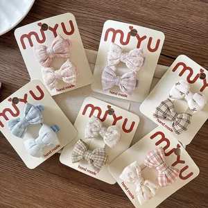 Detailed set of six handmade floral and plaid fabric bow hair clips for kids on display cards