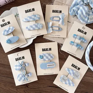 Detailed set of blue plaid bow hair clips and BB hairpins on display card