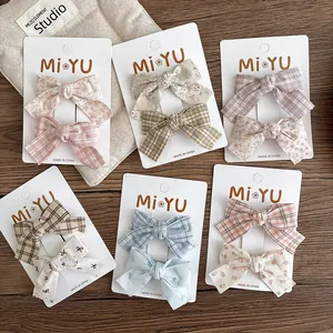Set of 12 floral bow hair clips for girls, featuring plaid patterns on display cards