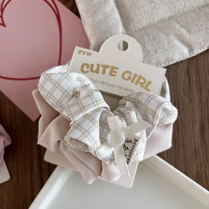 Detail of pink plaid scrunchie with cream ribbon bow and handmade label on card