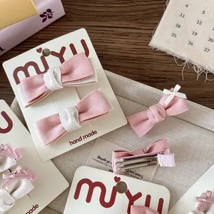 Fermagli per capelli con fiocco in tessuto rosa e beige per bambine su carta fatta a mano