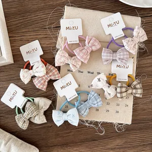 Floral and plaid bow hair ties for girls on a display card over a rustic table